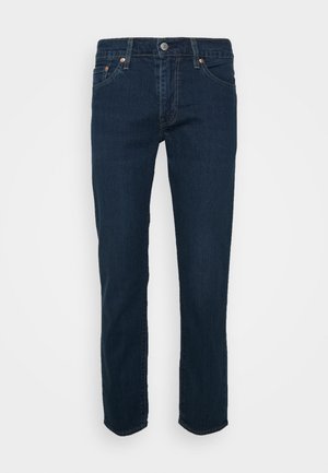 Dunkelblaue Jeans mit geradem Bein. Verfügt über fünf Taschen, einen Knopfverschluss und dezente Kupferakzente.