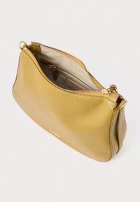 Sac à main en cuir jaune avec une surface texturée, une fermeture éclair dorée et un intérieur spacieux. Comprend une doublure neutre et une étiquette de marque discrète.