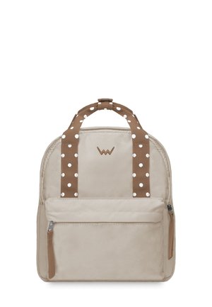 Beiger Stoff-Rucksack mit braunen Punkten auf den Trägern und einem vorderen Reißverschlussfach. Besitzt eine runde Form und ein Logo an der Oberseite.