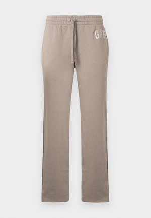 Pantaloni sportivi beige chiaro con fascia elastica in vita, coulisse e logo "GAP" ricamato sulla parte superiore della gamba sinistra. Tessuto morbido in cotone.