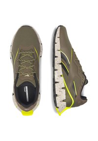 Brązowe buty sportowe z siateczkową cholewką, żółtymi akcentami i nakrapianą beżową podeszwą. Posiadają wyściełany kołnierz i trwałą, ząbkowaną podeszwę zewnętrzną.