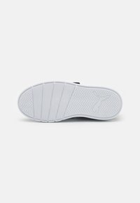 Semelle de chaussure en caoutchouc blanc avec un motif en zigzag texturé, comportant une empreinte de logo et de multiples rainures horizontales pour l'adhérence.