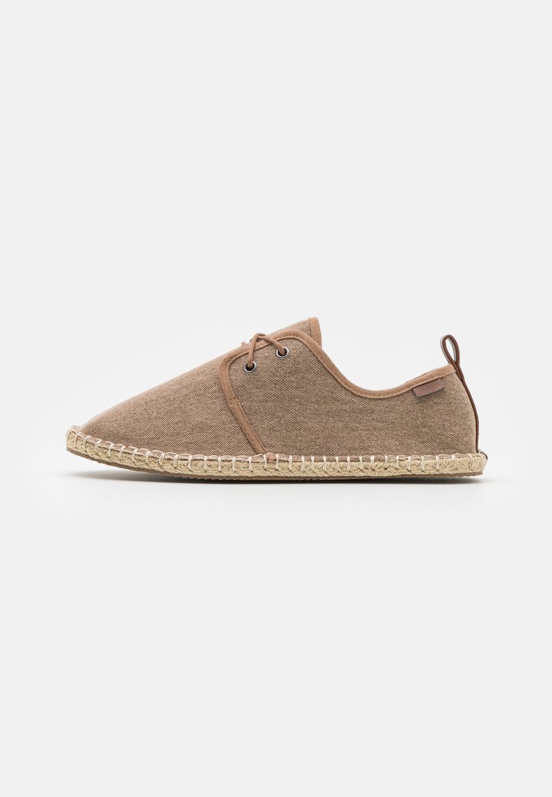 Espadrille en toile marron avec devant à lacets, semelle en jute cousue, et languette à l'arrière sur fond blanc.