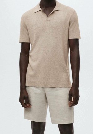 Polo beige à manches courtes avec une texture douce, doté d'un col et d'une coupe décontractée, associé à un short en lin léger de couleur similaire.