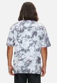 Överdimensionerad t-shirt med korta ärmar i tie-dye grå och vit. Tillverkad av bomull med en avslappnad passform och rund halsringning.