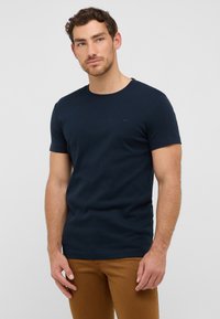 Granatowy t-shirt z krótkim rękawem, wykonany z gładkiej mieszanki bawełny, z okrągłym dekoltem i subtelnym detalem logo na klatce piersiowej.