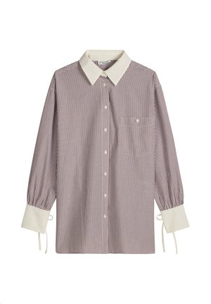 Chemise à manches longues à boutons avec de fines rayures verticales rouges, col pointu blanc, larges poignets blancs avec liens, et une poche poitrine.