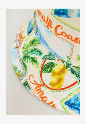 Kapa iz špirasta tkanina s potiskom limon, palmovih listov in obalnih prizorov. Svetlo bež ozadje z živahnimi barvami in detajli šivanja.