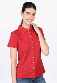 Red short-sleeve blouse with a collared neckline, featuring a cherry pattern and front button closure. Casual fit; soft fabric texture.