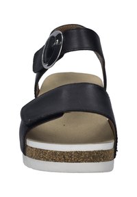 Schwarze Ledersandale mit verstellbarem Riemen, runder silberner Schnalle, wildlederähnlicher Innensohle und korkstrukturierter Keilsohle mit weißer Gummisohle.