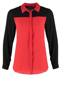 Blouse femme à manches longues avec manches et haut de poitrine noirs, corps et col rouges, et patte de boutonnage avant dissimulée.