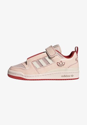 Light pink sneaker with a velcro strap, white stripes, and textured finish. Red accents on the sole and heel. Adidas logo on the side.