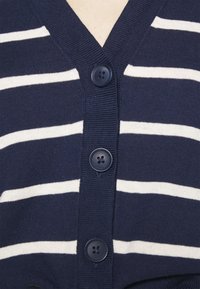 Granatowy kardigan z białymi poziomymi paskami, dekoltem w kształcie litery V oraz pięcioma ciemnymi guzikami z przodu, o dzianinowej fakturze.