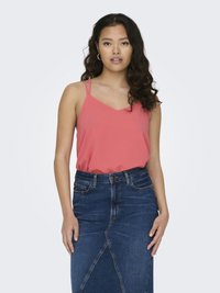 Koraalkleurige tanktop met dunne bandjes en een V-hals ontwerp, gecombineerd met een spijkerrokken met een diagonale naad en voorzakken.