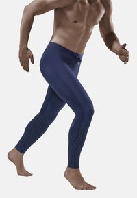 Marineblauwe actieve leggings hebben een gladde textuur, een aansluitend ontwerp en diamantpatroonaccenten op de onderbenen.