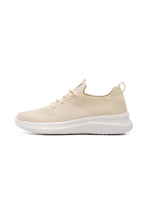 Zapatilla deportiva beige con parte superior de tejido transpirable y cierre de cordones. Suela blanca gruesa con detalles texturizados, que ofrece amortiguación y soporte.