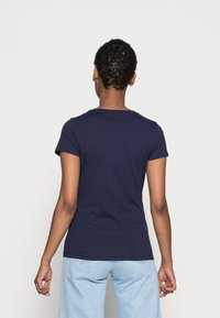 Marinblå, figursydd t-shirt i bomull med korta ärmar och rund halsringning; slät textur; enkel design utan mönster eller grafik.