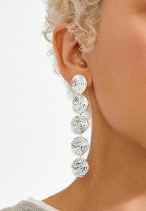 Sudraba auskari ar četrām spirāles dizaina detaļām, izgatavoti no teksturēta metāla, katrs ar gludu apaļu augšdaļu.