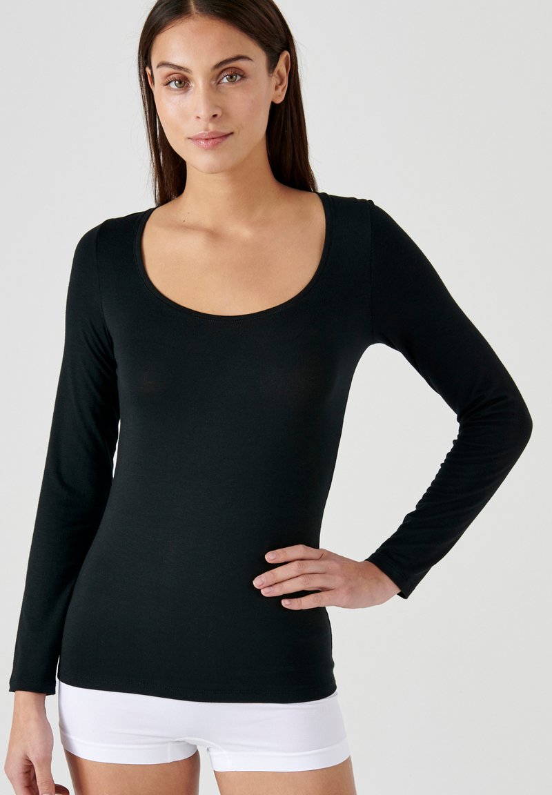 Top nero a maniche lunghe con scollo rotondo, realizzato in tessuto morbido. Caratterizzato da un design aderente, una superficie liscia e dettagli di cucitura minimi.