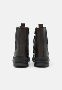 Black ankle boots made of leather with a smooth finish, elastic side panels, and textured rubber soles. Features dual zippers for easy wear.