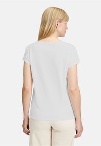 Hvid kortærmet t-shirt med afslappet pasform, rund halsudskæring, blødt stof og subtile syninger på skuldrene.