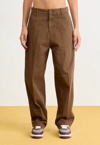Pantalon marron taille haute à coupe ample et décontractée. Fabriqué en tissu lisse avec une fermeture à boutons sur le devant et des poches latérales.