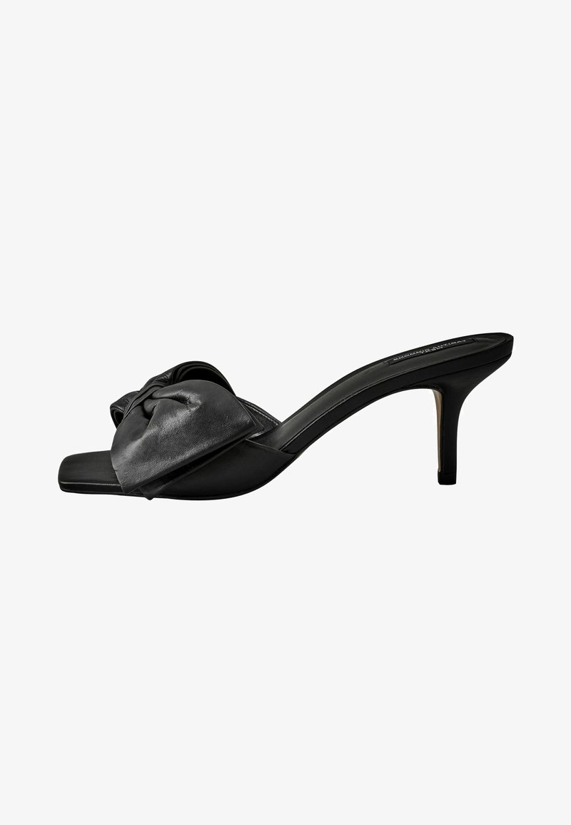 Črne usnjene mule na peto z vozeljasto podrobnostjo na zgornjem traku in gladko površino. Kvadratna konica in ozka stiletto peta.
