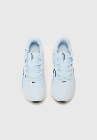 Világoskék sportcipők hálós felsőrésszel, lapos fűzőkkel, fekete logóval és fehér talppal. Sleek, kerek orrú design jellemzi.