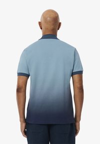 Kortärmad pikétröja med en gradientdesign från ljusblå till marinblå, med en enfärgad marinblå krage och ribbade ärmslut.