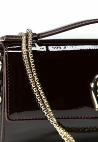 Bolso burdeos brillante con forma estructurada, con una correa de cadena dorada y detalles metálicos dorados en la parte frontal.