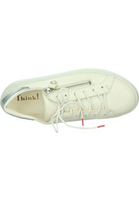 Weiße Leder-Sneaker mit einem Reißverschluss, silbernem Akzent an der Ferse und weißen Schnürsenkeln. Mit roter und weißer Verzierung an den Schnürsenkeln.