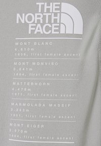 Logo The North Face s výčtem evropských hor, jejich výšek a let prvních ženských výstupů.
