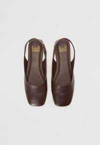 Brūni ādas slingback apavi ar kvadrātu purngaliem un mīkstu tekstūru, ar sānu rāvējslēdzēju aizdarei un minimālisma dizainu.