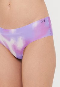 Lilla ja roosa tainastikandiga bikiinipüksid, millel on sile tekstuur ja madal talje disain. Taljeosa peal on väike must Under Armour'i logo.