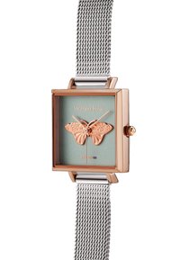 Montre rectangulaire avec un boîtier en or rose, cadran vert arborant un motif de papillon, et un bracelet en maille argentée.