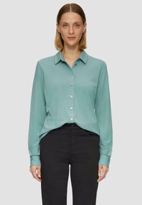 Langdurige button-up shirt in teal stof, met een kraag en zilveren knopen, gecombineerd met zwarte broek, vlakke textuur.