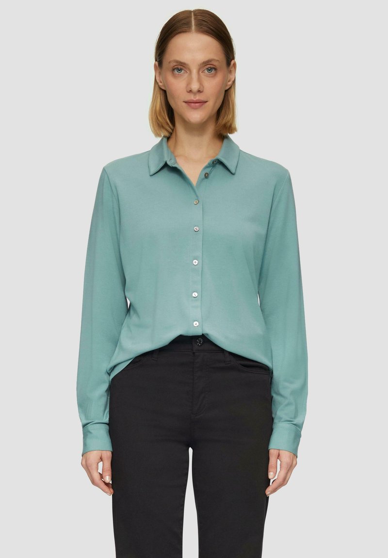 Langdurige button-up shirt in teal stof, met een kraag en zilveren knopen, gecombineerd met zwarte broek, vlakke textuur.