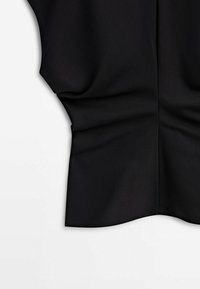 Pièce de tissu noir avec un léger drapé et un détail de taille froncée sur un fond blanc.