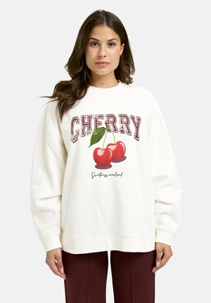 White sweatshirt with "CHERRY" text and cherry graphic. Features dropped shoulders and ribbed cuffs. Soft material with loose fit.