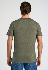 Oliwkowa koszulka z krótkim rękawem o teksturowanym wykończeniu, okrągłym dekolcie i slim fit. Posiada małe logo blisko dołu.