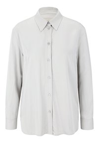 Schlichte, lange weiße Button-Up-Hemd mit spitzem Kragen und geknöpften Manschetten, vor einem einfarbigen Hintergrund präsentiert.