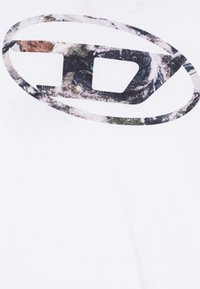 Abstraktný oválny tvar dizajnu s nepravidelnými tmavými a svetlými škvrnami na bielom látkovom pozadí.