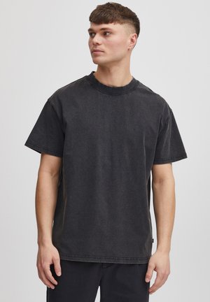 Black short-sleeve t-shirt with a round neckline, made from textured fabric, featuring visible stitching and a relaxed fit.