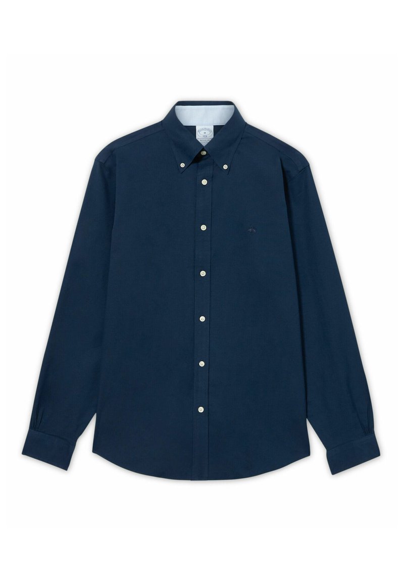 Camicia blu navy a maniche lunghe con bottoni e collo con laccetto, con bottoni bianchi, distesa su uno sfondo bianco.