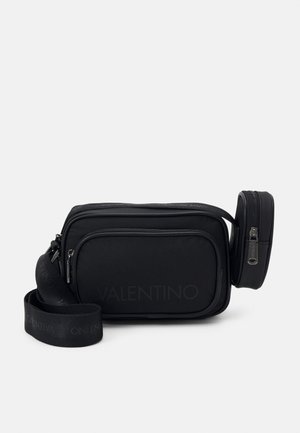 Sac bandoulière rectangulaire noir avec compartiments zippés à l'avant et sur les côtés, sangle de marque ajustable et logo Valentino discret sur le tissu.