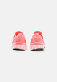 Scarpe sportive rosa con tomaia in rete testurizzata e suola in gomma. Il design presenta un colletto imbottito e un battistrada decorato per una migliore aderenza.