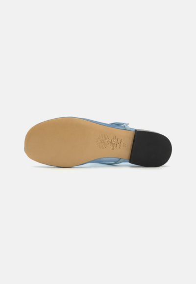 Sola de sapato de couro azul com um fundo em tom de caramelo, apresentando um padrão texturizado e um salto preto. Logótipo da marca estampado na zona do salto.