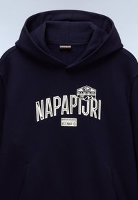 Hanorac cu glugă de culoare albastru marin, fabricat dintr-un amestec de bumbac, având un logo alb îngroșat "NAPAPIJRI" și o etichetă mică cu "EST.1987.". Buzunar frontal tip kangaroo.