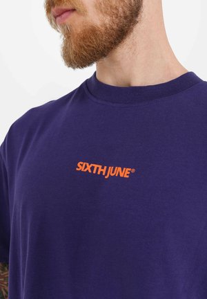 Purple T-shirt made of cotton with a round neckline. Features an orange "SIXTH JUNE®" logo on the chest. Soft texture, short sleeves.