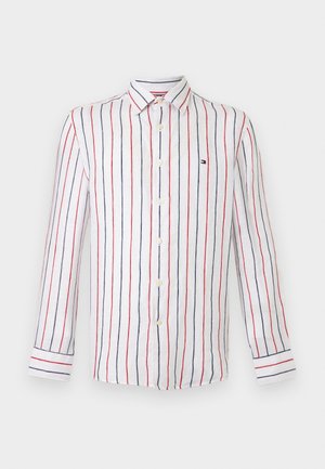 Chemise blanche à manches longues avec des rayures verticales rouges et bleues et un petit logo brodé sur le côté gauche de la poitrine.